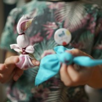 Zdjęcie dziecka trzymającego dwie motanki, niebieską i różową.