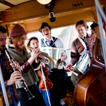 Zdjęcie członków zespołu grających wewnątrz starego tramwaju.