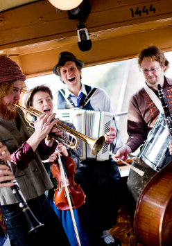 Zdjęcie członków zespołu grających wewnątrz starego tramwaju.
