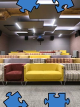 Zdjęcie kolorowych kanap w sali filmowej. W obramowaniu zdjęcia niebieskie puzzle.