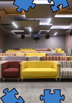 Zdjęcie kolorowych kanap w sali filmowej. W obramowaniu zdjęcia niebieskie puzzle.