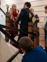 Na zdjęciu grupa ludzi na schodach, we wnętrzach Biblioteki Raczyńskich.