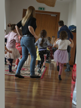 Na zdjęciu znajduje się grupa dzieci razem z prowadzącą warsztaty taneczne.