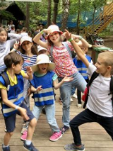 Zdjęcie przedstawia grupkę dzieci bawiących się na półkolonii