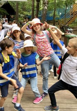 Zdjęcie przedstawia grupkę dzieci bawiących się na półkolonii