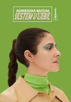 Na zdjęciu artystka na tle zielonego tła.