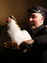 Zdjęcie aktora z białą kurą w trakcie spektaklu.