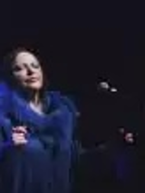 Zdjęcie artystki w niebieskiej sukni na scenie.