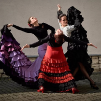 Zdjęcie trzech tancerek flamenco w typowych kobiecych strojach.