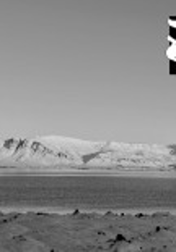 Czarno-białe zdjęcie z widokiem morza i gór.