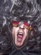 Zdjęcie meżczyzny w kolorowych okularach i z burzą szarych włosów.