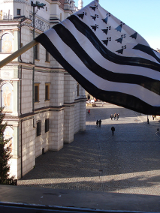 Białoczarna flaga Bretanii powiewająca na tle Ratusza Poznańskiego