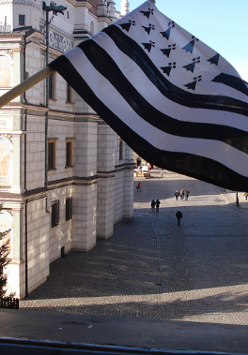Białoczarna flaga Bretanii powiewająca na tle Ratusza Poznańskiego