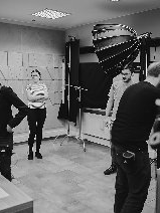 kilkoro ludzi na planie filmowym w kolorach czarnym i białym