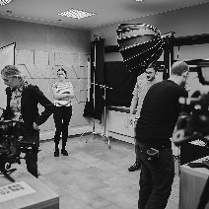 kilkoro ludzi na planie filmowym w kolorach czarnym i białym