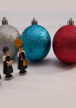 Trzy kolorowe bombki i figurki przedstawiające trzech króli.
