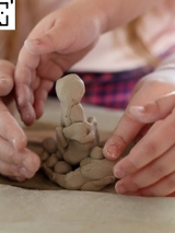 dziecięce i dorosłe dłonie ujęte podczas lepienia pracy z gliny.