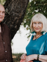 Zdjęcie mężczyzny i kobiety - uczestników spotkania - na tle drzew.