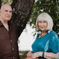 Zdjęcie mężczyzny i kobiety - uczestników spotkania - na tle drzew.