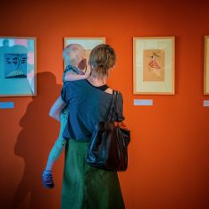 kobieta z dzieckiem na rękach oglądająca obrazy