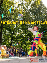 Kolorowo ubranie artysci przed widownią na tle zielonych drzew