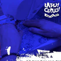 Grafika wykorzystująca zdjęcie dłoni przesuwających materiał na maszynie do szycia. Fotografia utrzymana w fioletowych barwach.