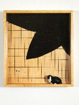 w kwadratowym obrazie z prostopadła ramą jest postawiony czarnobialy kot, tlo jest bezowe z czarnym duzym fragmentem jakby liścia