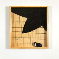 w kwadratowym obrazie z prostopadła ramą jest postawiony czarnobialy kot, tlo jest bezowe z czarnym duzym fragmentem jakby liścia