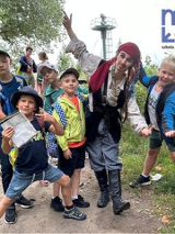 chłopcy wraz z mężczyzną przebranym za pirata w plenerze