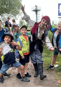 chłopcy wraz z mężczyzną przebranym za pirata w plenerze