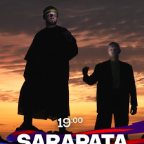 zdjecie 2 wykonawców na tle zachodzącego słońca