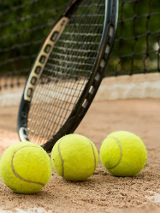 Paletka i piłki do tenisa na tle boiska