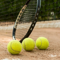 Paletka i piłki do tenisa na tle boiska