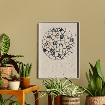 okragła mozaika z białych i niebieskich elementów w ramce zawieszona na ścianie