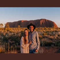 Młoda, uśmiechnięta para na tle australijskiego krajobrazu.