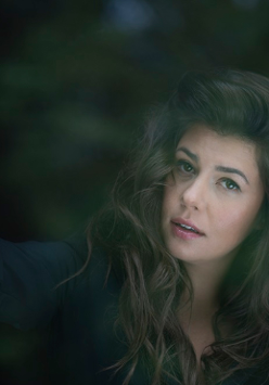 Monika Borzym pozuje do zdjęcia z dłonią wplątaną we włosy.