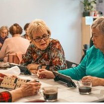 Grupa kobiet gra w Rummikub przy kawie.