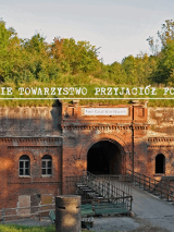 Widok na wejście do Fortu III, na środku napis: "Poznańskie Towarzystwo Przyjaciół Fortyfikacji".