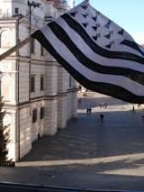 Na zdjęciu flaga Bretanii na tle ratusza w Poznaniu.