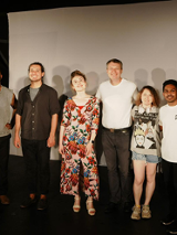 Zdjęcie zespołu aktorów Open City International Theatre - osiem osób stojących obok siebie, wszyscy się uśmiechają.