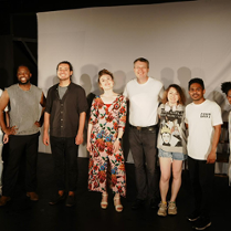 Zdjęcie zespołu aktorów Open City International Theatre - osiem osób stojących obok siebie, wszyscy się uśmiechają.