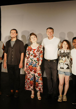 Zdjęcie zespołu aktorów Open City International Theatre - osiem osób stojących obok siebie, wszyscy się uśmiechają.
