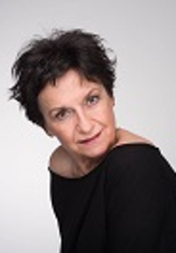 Zdjęcie Danieli Popławskiej w czarnej bluzce na jasno-szarym tle.