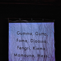 .Pognieciona kartka paperu, na której napisanych jest kilka słów, np. Gumma, Gutta, Foma. Czarne tło.