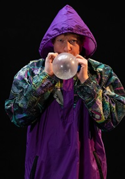 Photo of a man blowing a baloon.