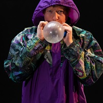 Photo of a man blowing a baloon.