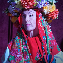 Zdjęcie kobiety w kolorowej chuście i wianku na głowie.