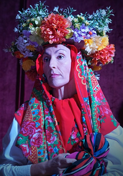 Zdjęcie kobiety w kolorowej chuście i wianku na głowie.