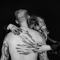 Czarno-białe zdjęcie kobiety obejmującej mężczyznę, twarze kobiety i mężczyzny są niewidoczne.