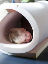 Zdjęcie uśmiechniętego dziecka w tubie z gąbki.